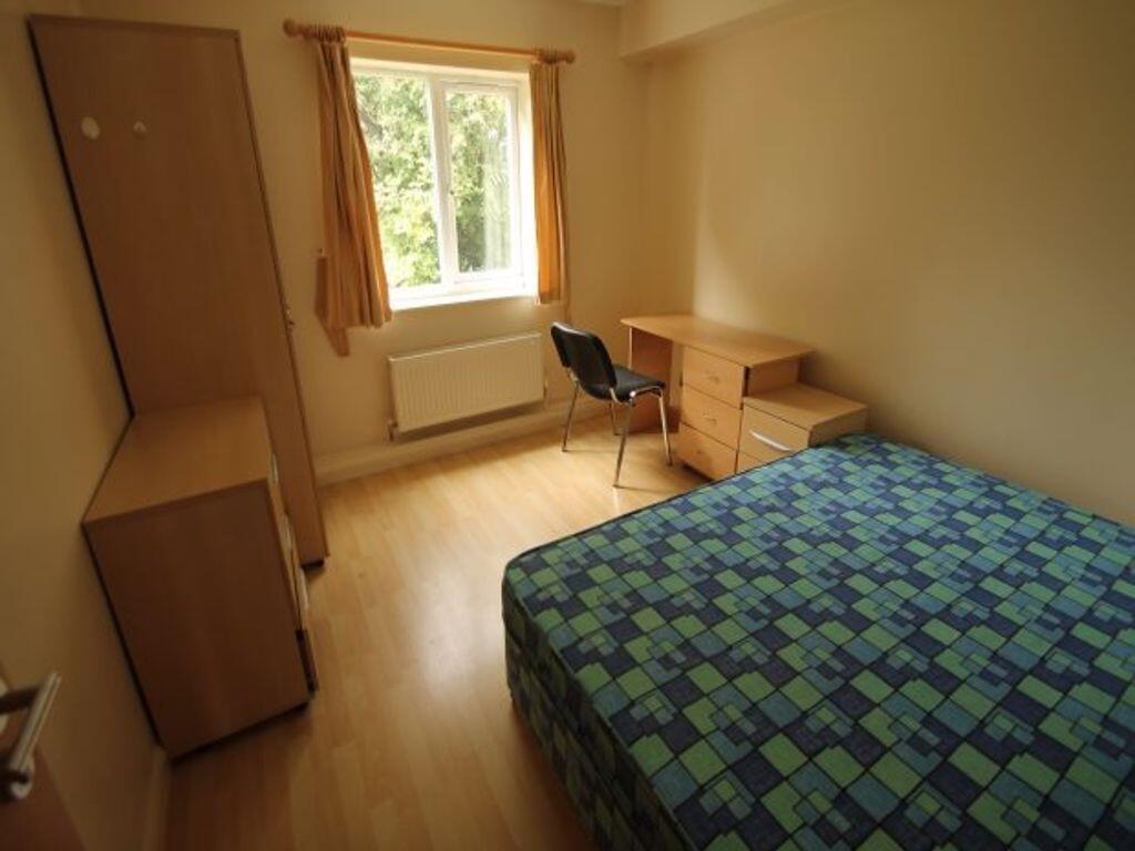 A cozy single bedroom featuring a window that l...