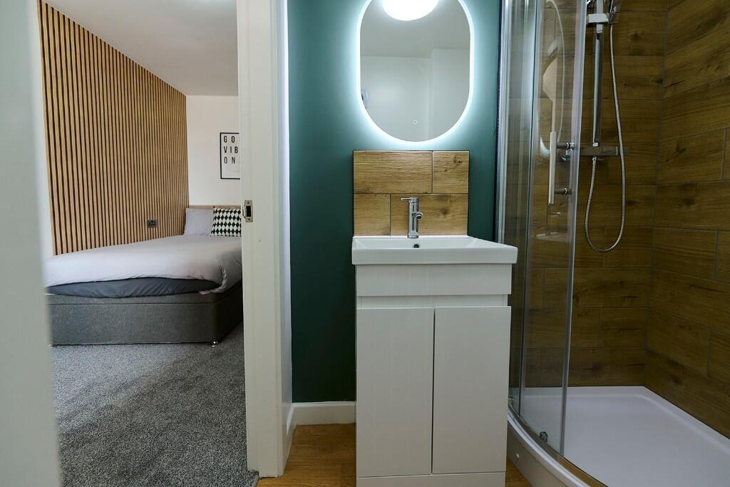 A modern master bedroom with a cozy double bed,...