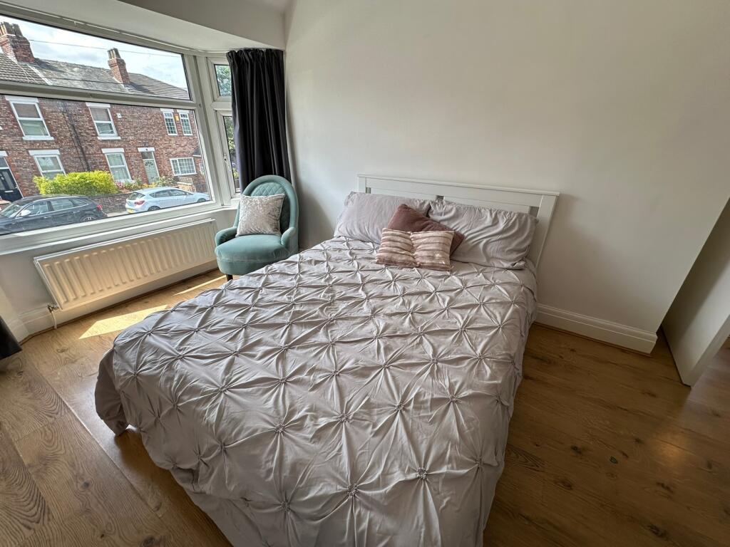 This inviting double bedroom features a cozy la...