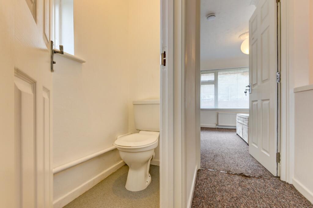 Bright and tidy single toilet with a clear whit...