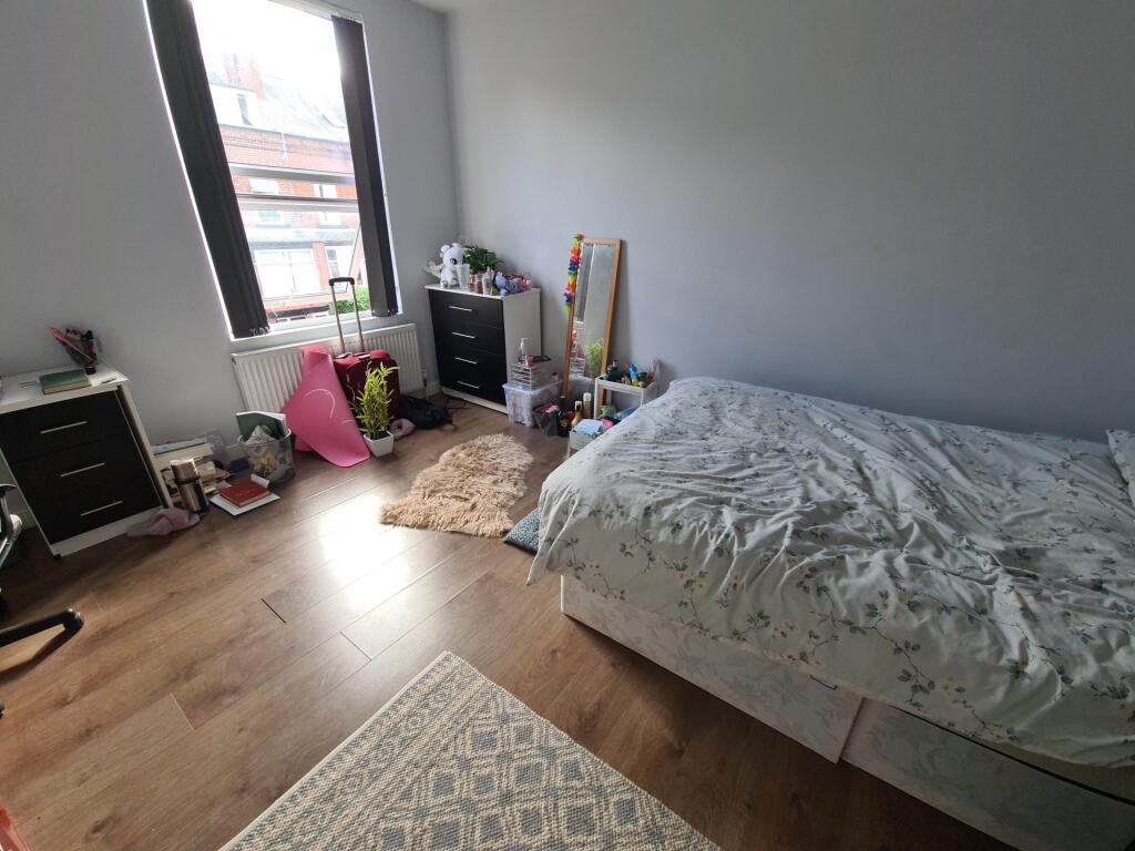 A cozy and bright bedroom with a single bed, wo...