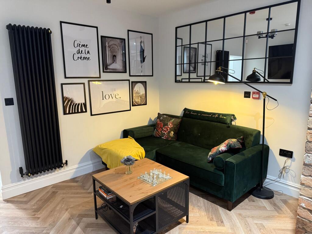 A stylish living room featuring a dark green ve...