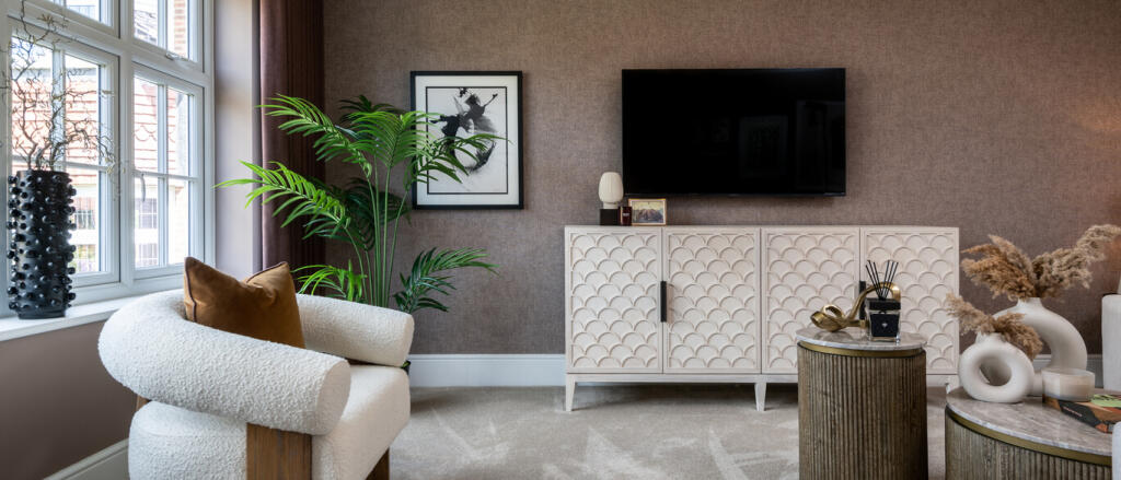 Modern living room with a textured brown feature wall, white cabinet, mounted TV, armchair with cush