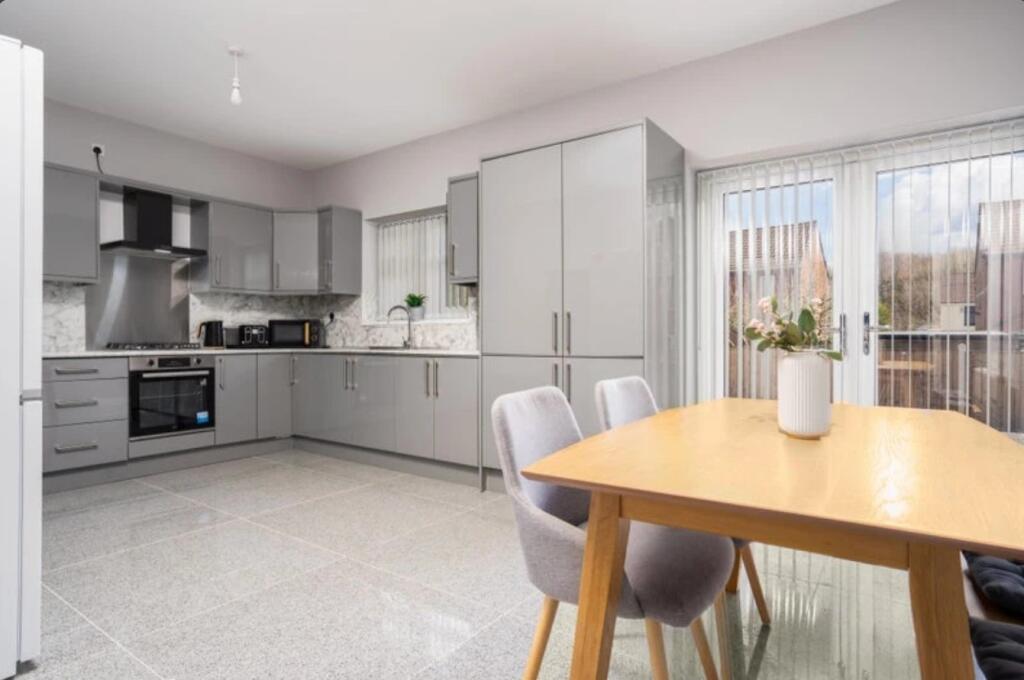 This modern kitchen features sleek grey cabinet...