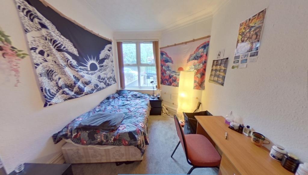 Cozy single bedroom featuring a comfortable bed...