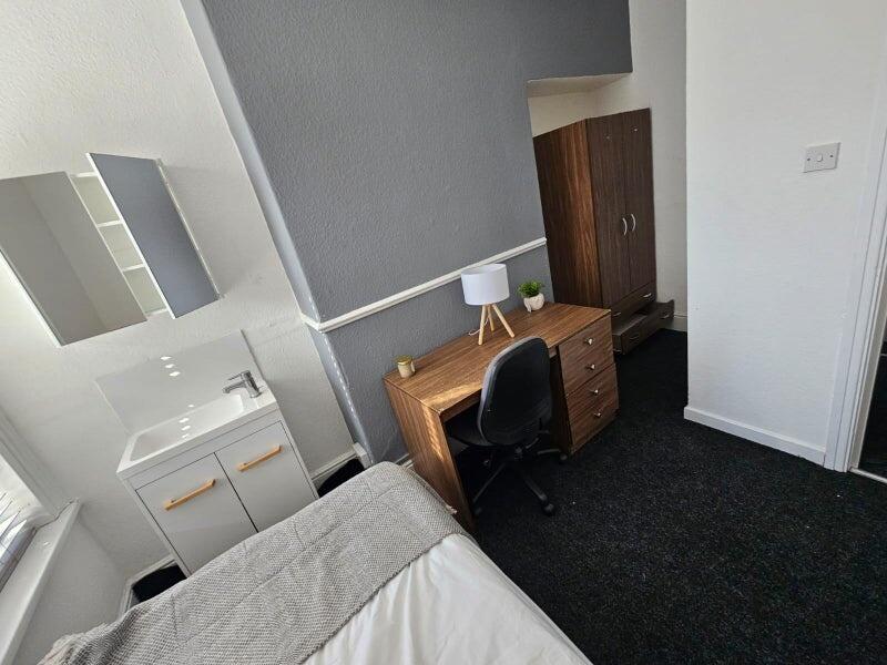 A cozy single bedroom featuring a comfortable b...