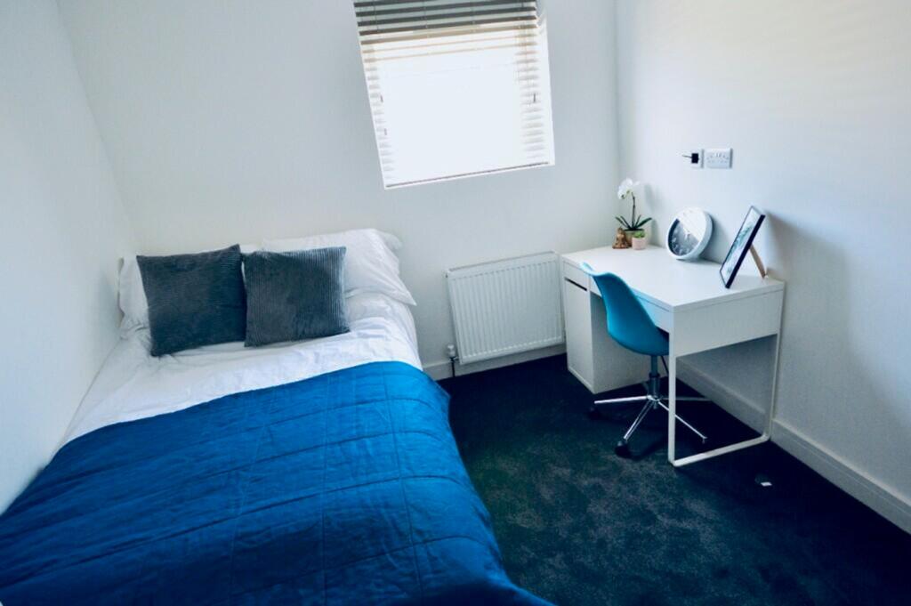 A bright and tidy double bedroom featuring a co...