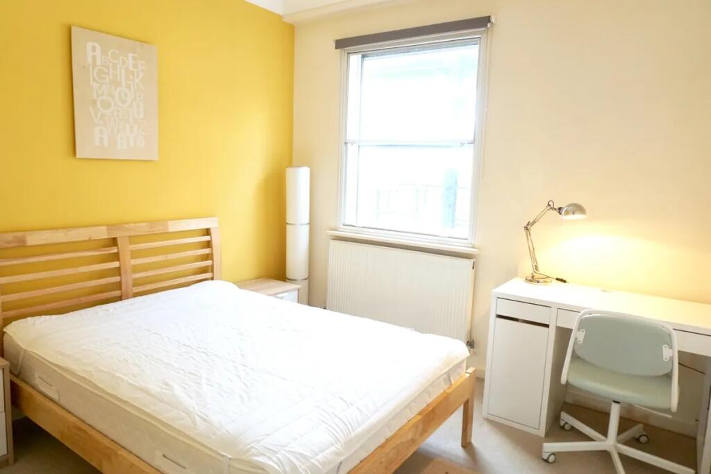 Bright and welcoming double bedroom featuring a...