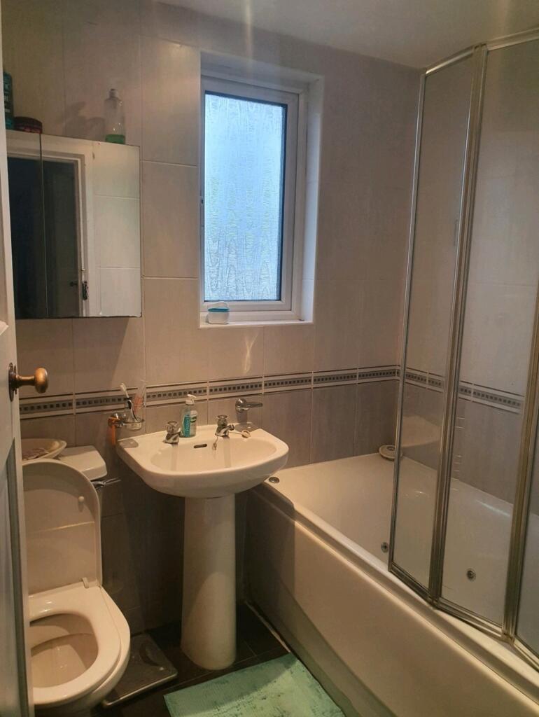 A tidy bathroom featuring both a bath and a sho...