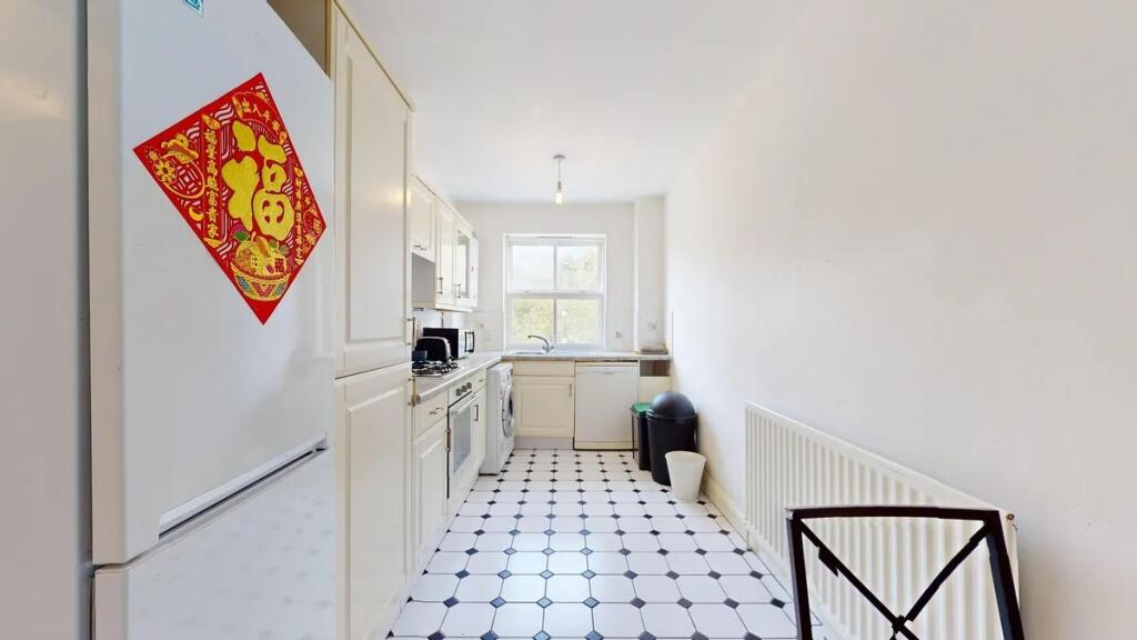 Bright and tidy kitchen featuring white cabinet...