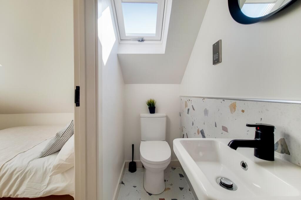 Bright and tidy bathroom featuring a toilet, sm...