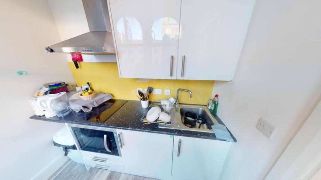 A modern kitchen featuring sleek white cabinets...