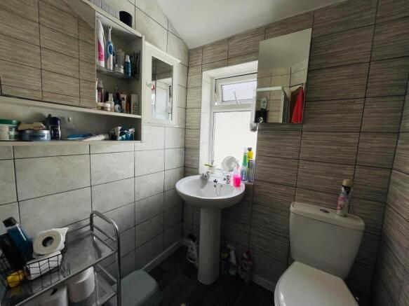 Bright and tidy bathroom featuring modern tilin...