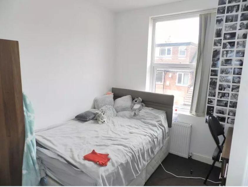 A bright single bedroom featuring a comfortable...