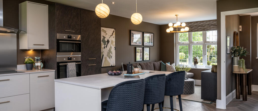Harrogate kitchen internal with white and navy tones, plus an island with bar stools