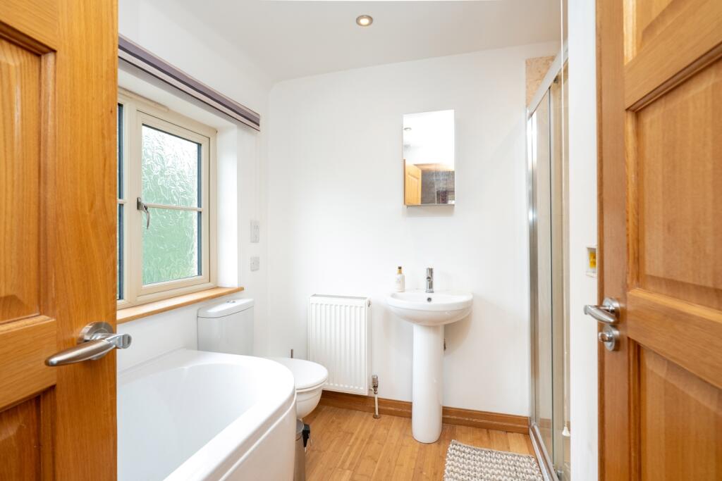 A bright Jack and Jill bathroom with a bathtub wit