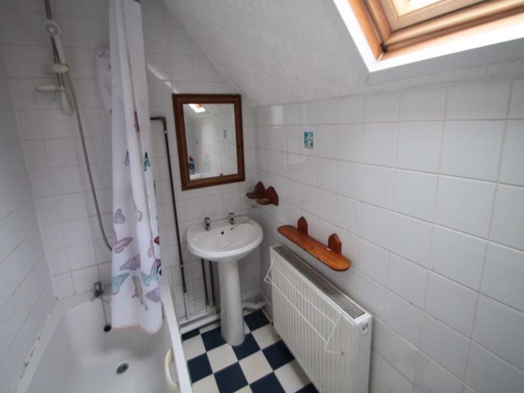 Bright upstairs bathroom with a skylight, white...
