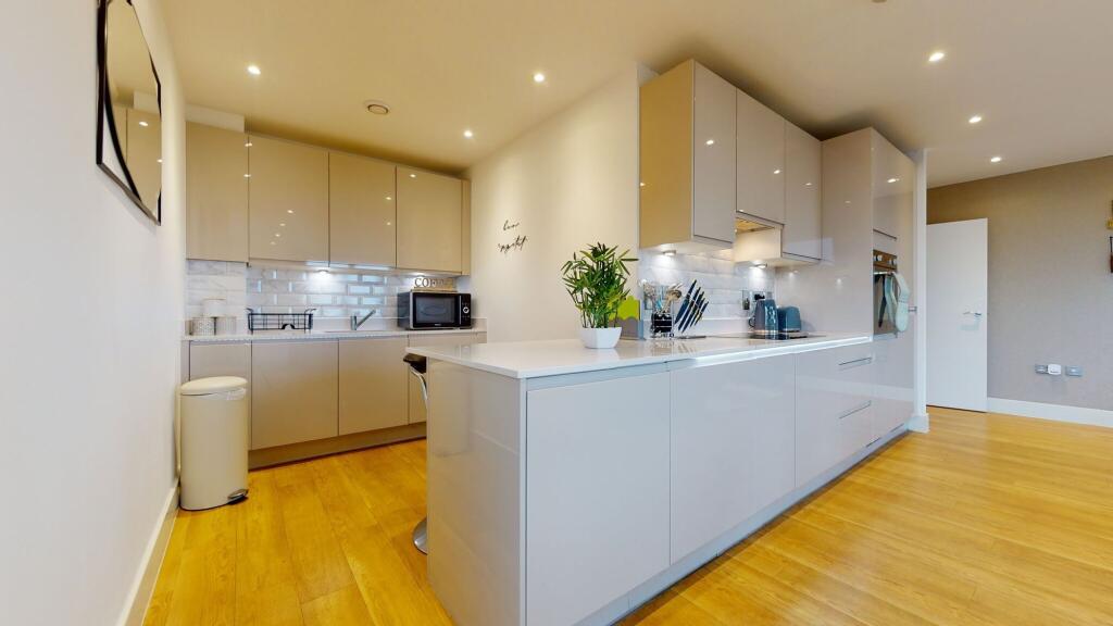 A modern kitchen featuring sleek cabinetry, a s...
