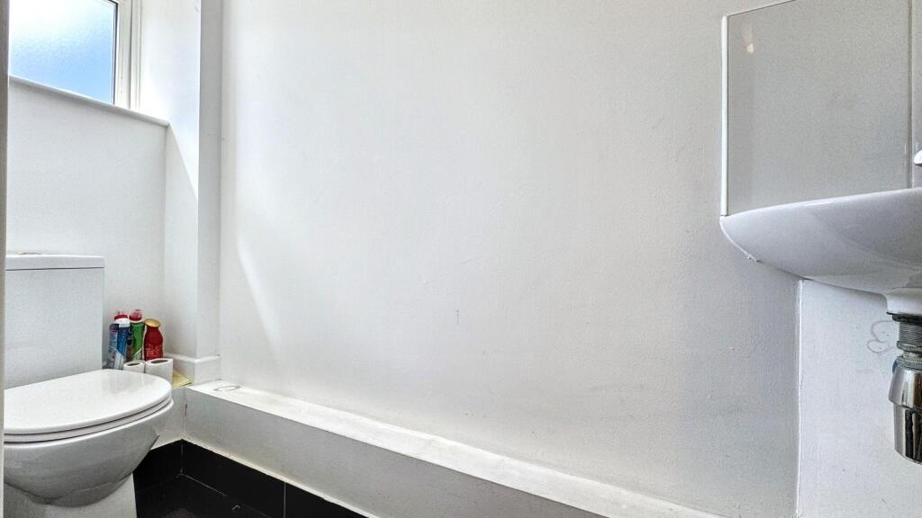 A clean, simple bathroom featuring a white bath...