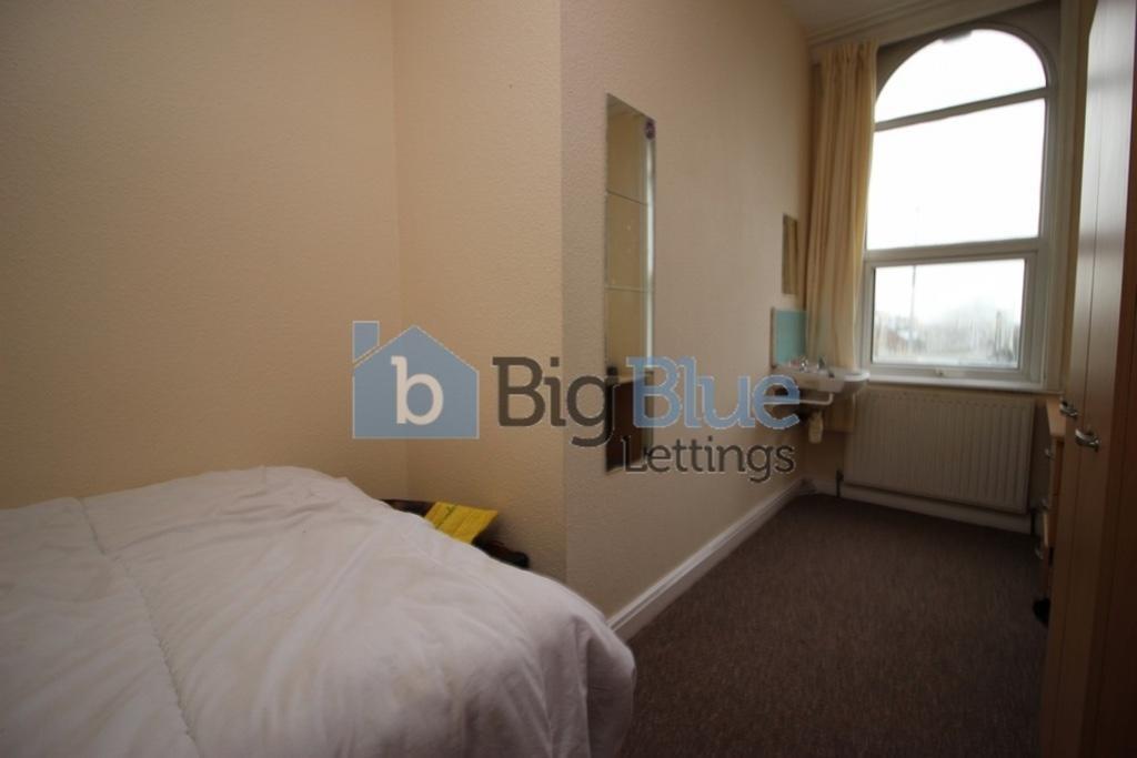 A cozy single bedroom with a comfortable bed, a...