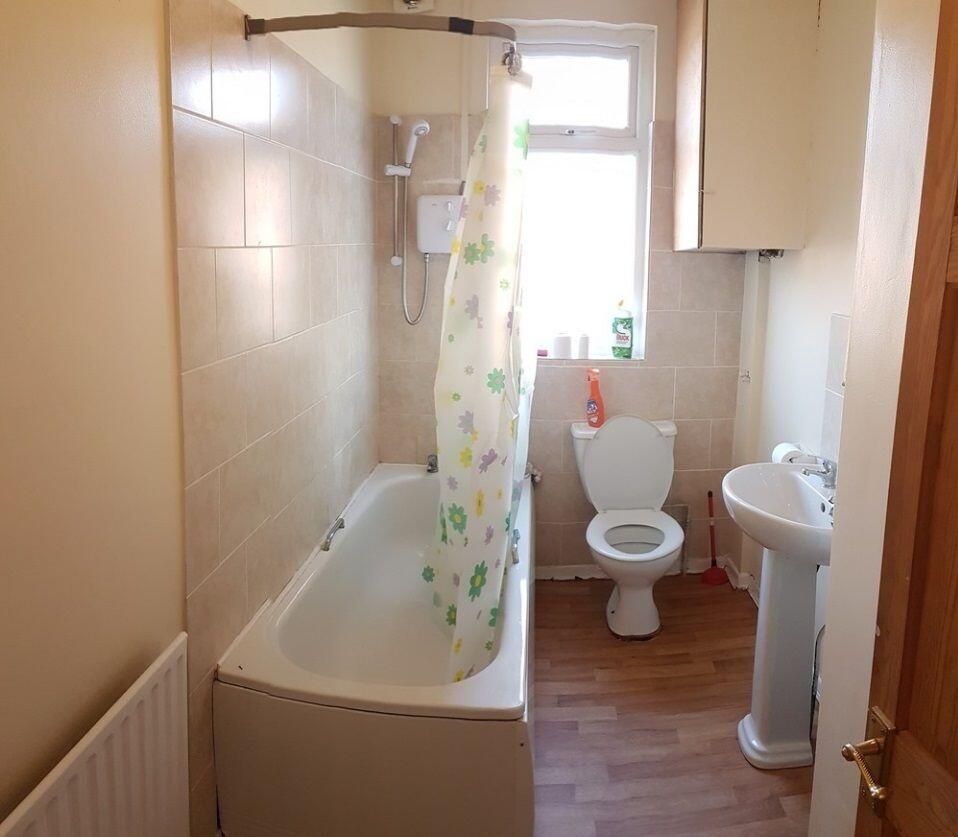 Bright bathroom with a shower-over-bath, pedest...