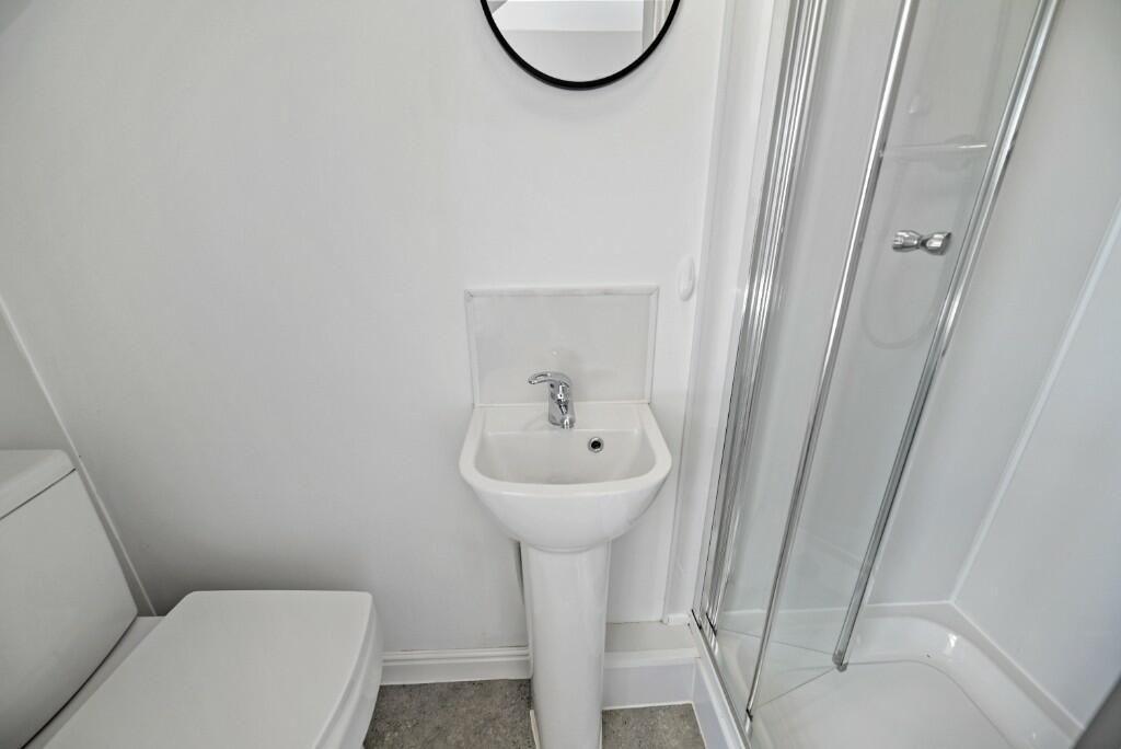 A clean and modern bathroom featuring a compact...