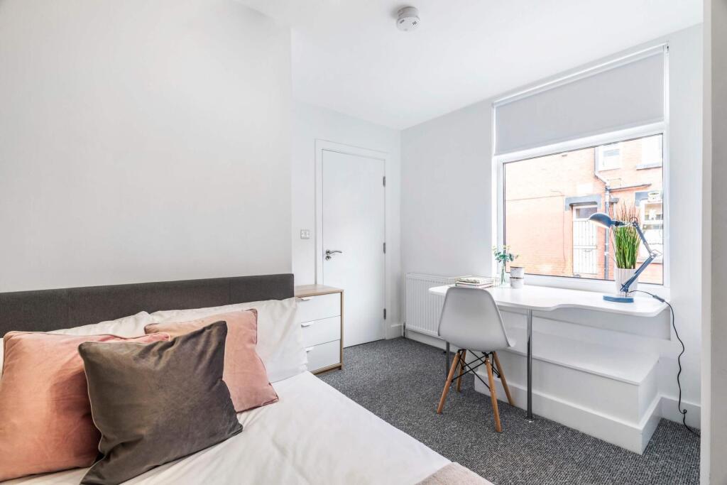 A bright and welcoming bedroom featuring a larg...