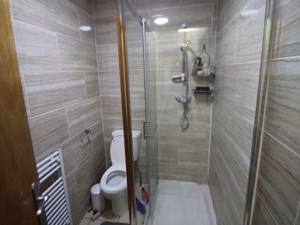 A modern bathroom featuring a glass-enclosed sh...