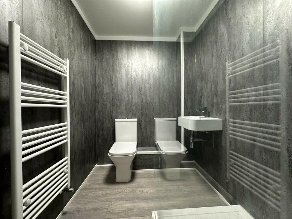 A modern, clean bathroom with a toilet and sink...