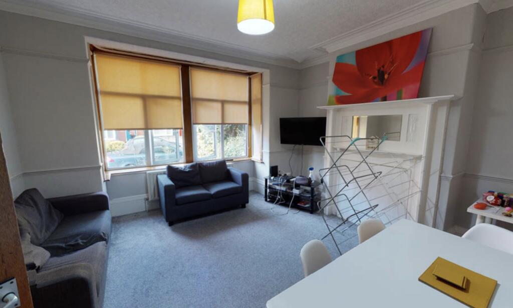 A spacious and well-lit living room featuring m...