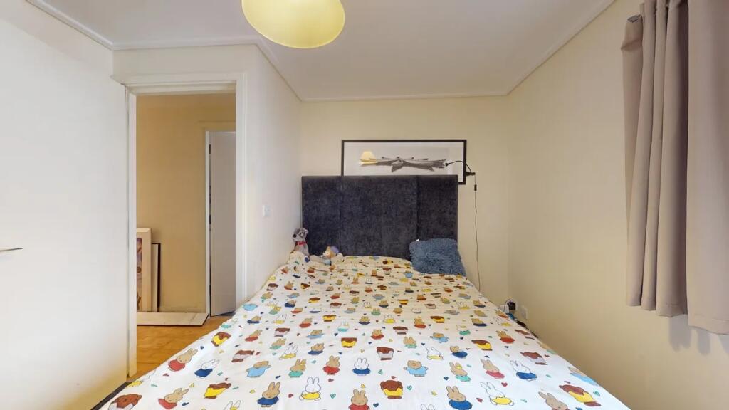 A cozy double bedroom featuring a charming patt...