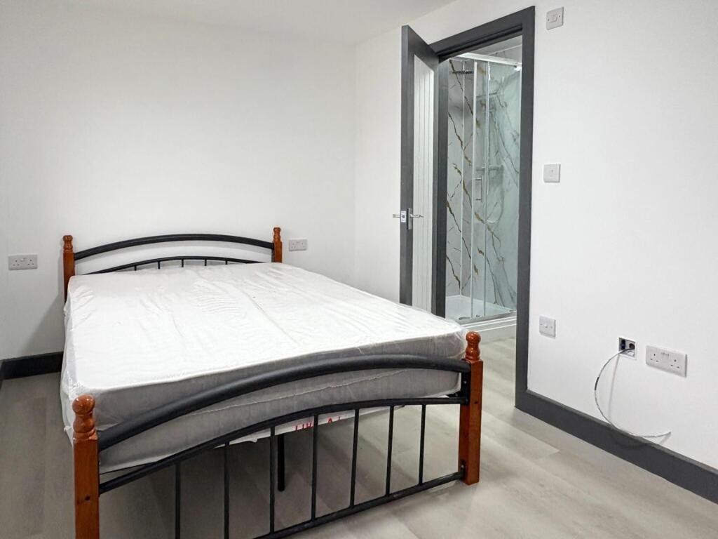 Bright, simply furnished bedroom with a double ...