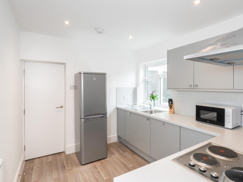 A modern and clean kitchen featuring sleek grey...