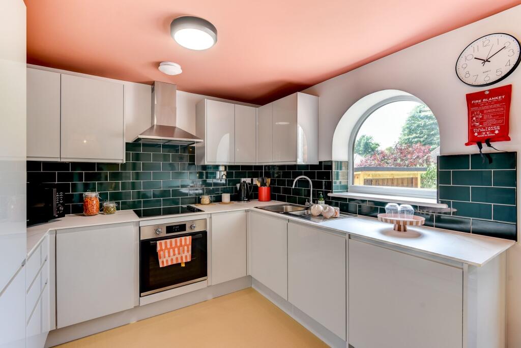 Bright and modern kitchen featuring sleek white...