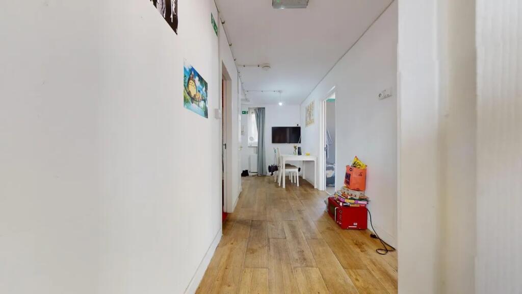 A bright and clean hallway with light wood floo...