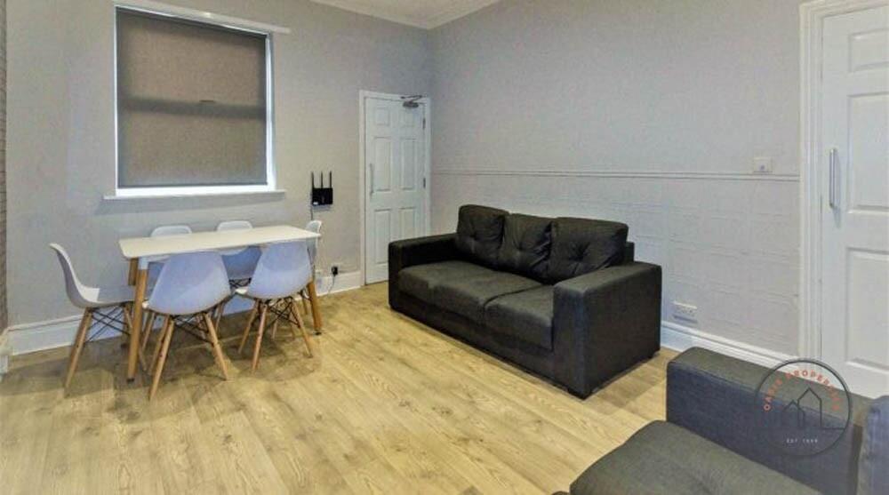 Bright, modern living area with light wood floo...