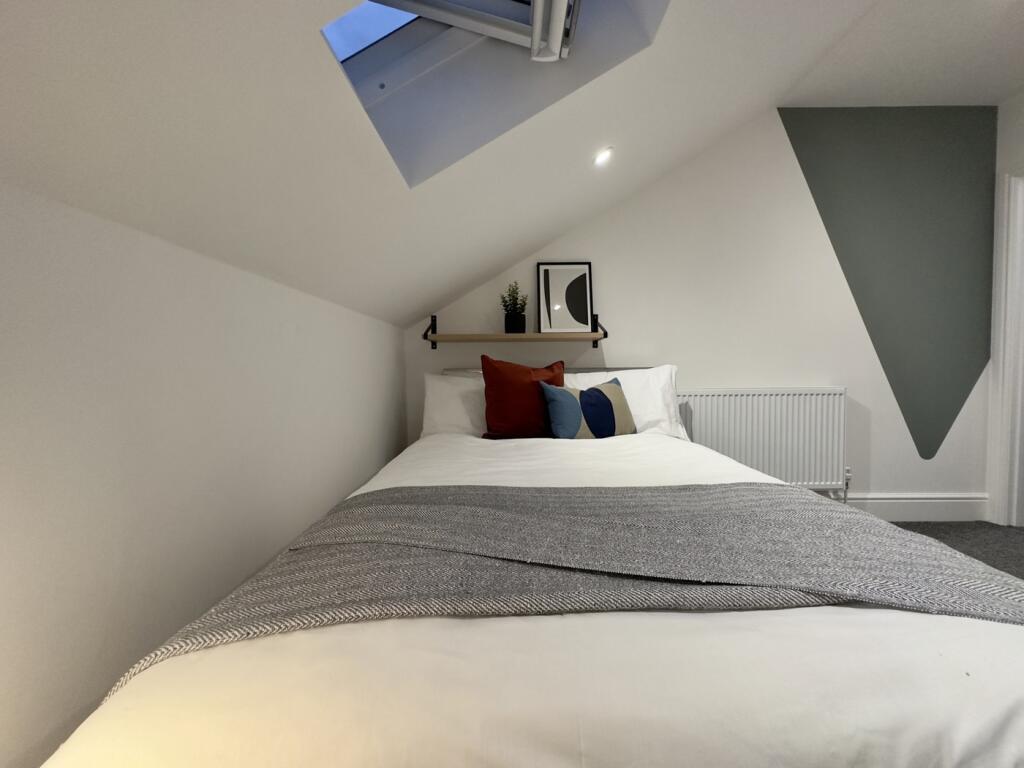 A beautifully arranged double bedroom with mode...