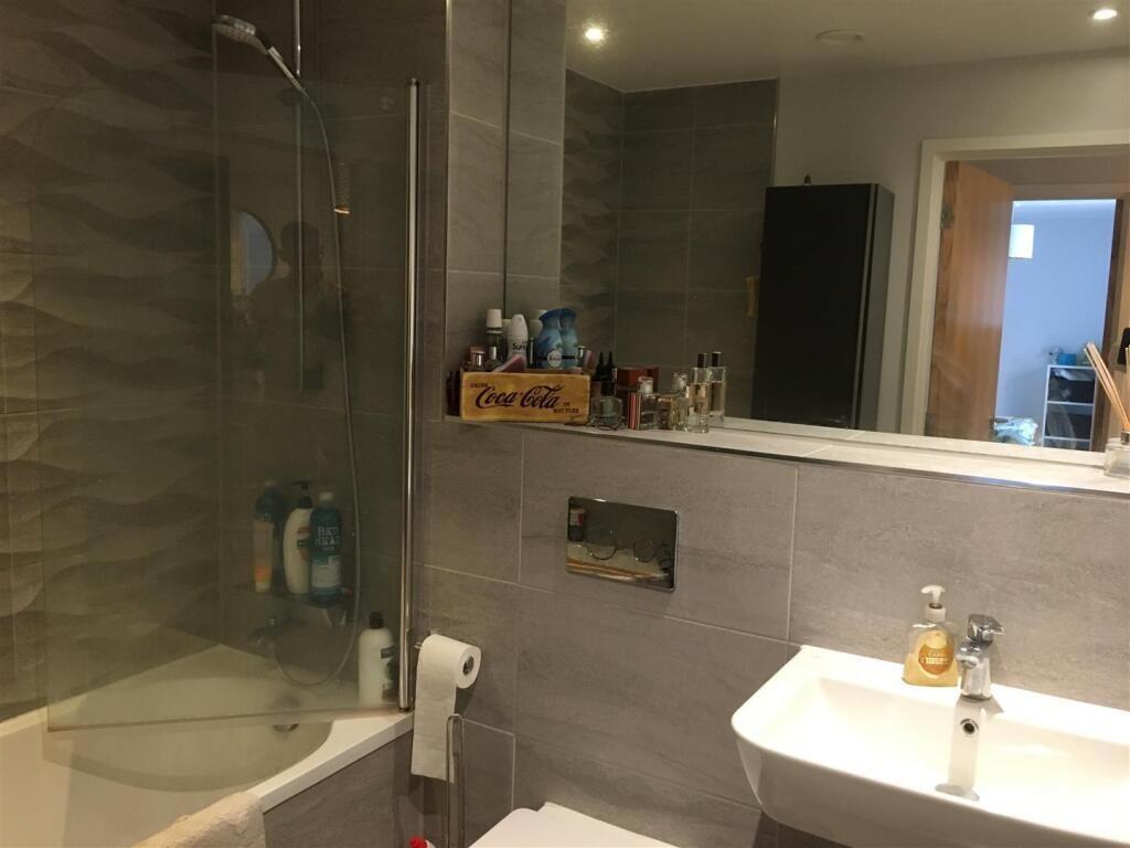 A modern bathroom suite featuring a sleek batht...