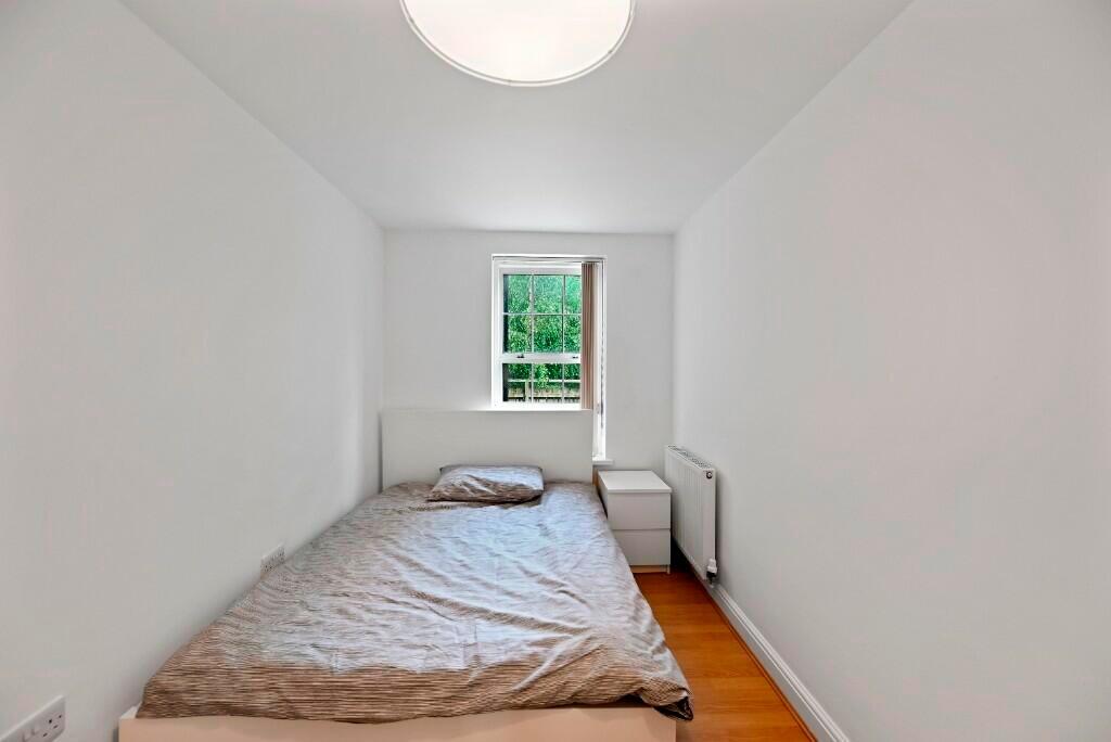 A neat and simple bedroom featuring a single be...