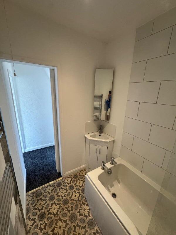 A bright and clean bathroom suite featuring a m...