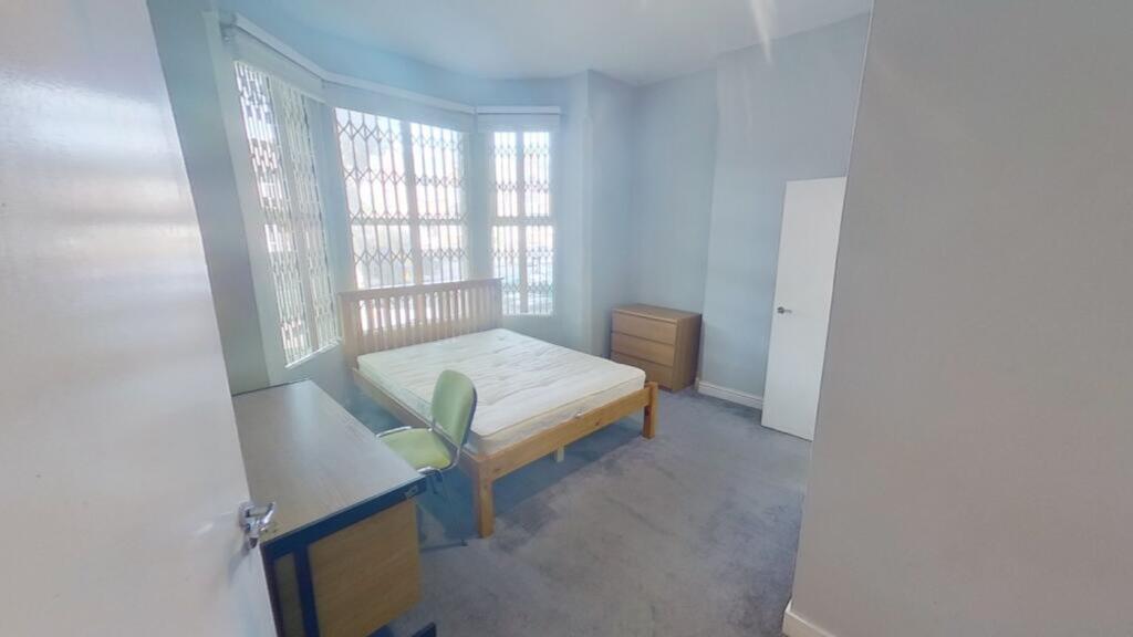 A spacious and bright double bedroom with large...