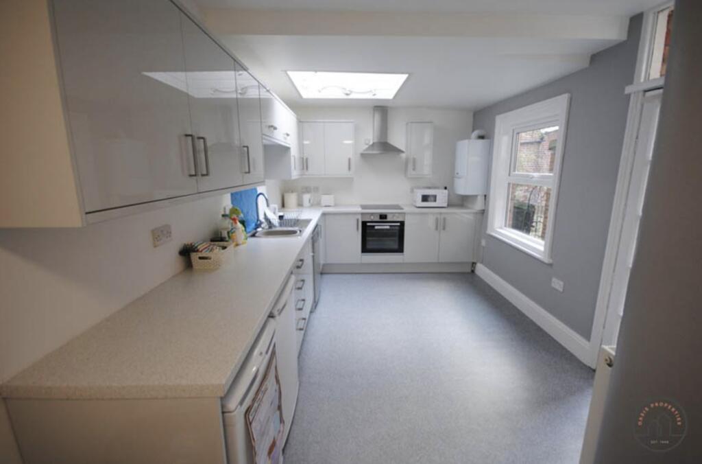Bright and clean kitchen area featuring white c...