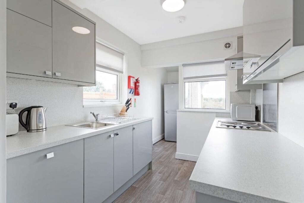 A modern and tidy kitchenette featuring ample s...