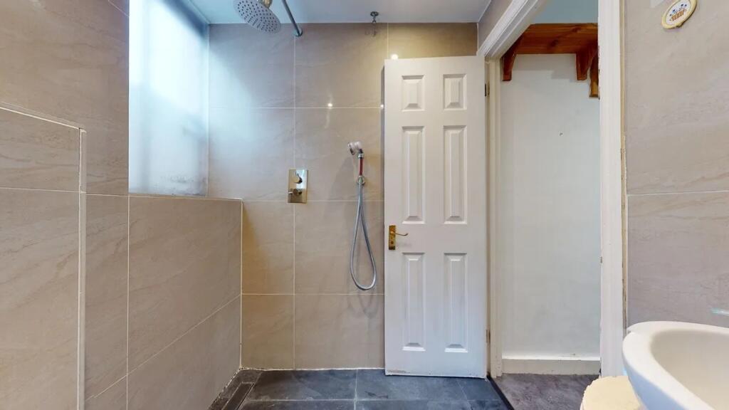 A modern bathroom featuring beige tiled walls a...