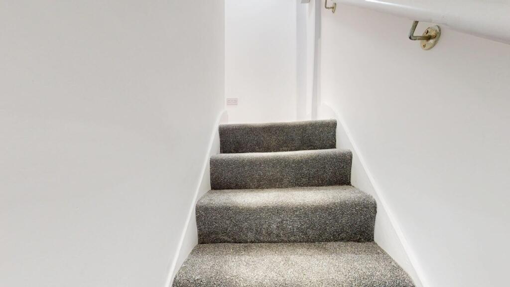 An indoor staircase with carpeted steps, simple...