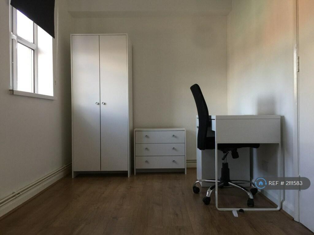 A spacious and tidy double bedroom featuring a ...