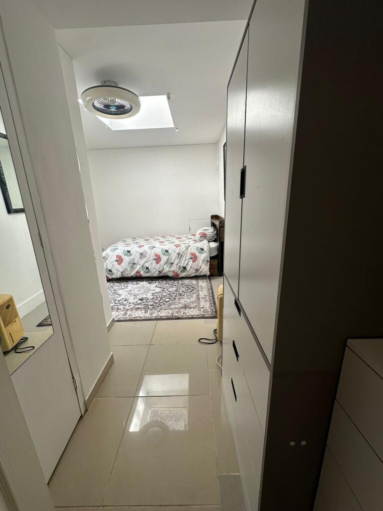 Bright, tidy bedroom with a patterned double be...