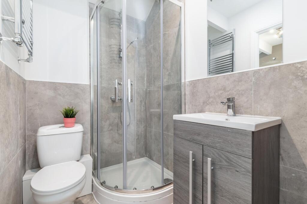 Contemporary bathroom with a corner glass showe...