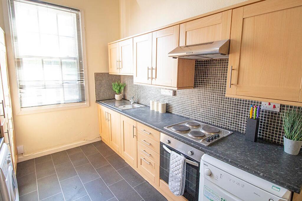 Bright and modern kitchen featuring sleek cabin...