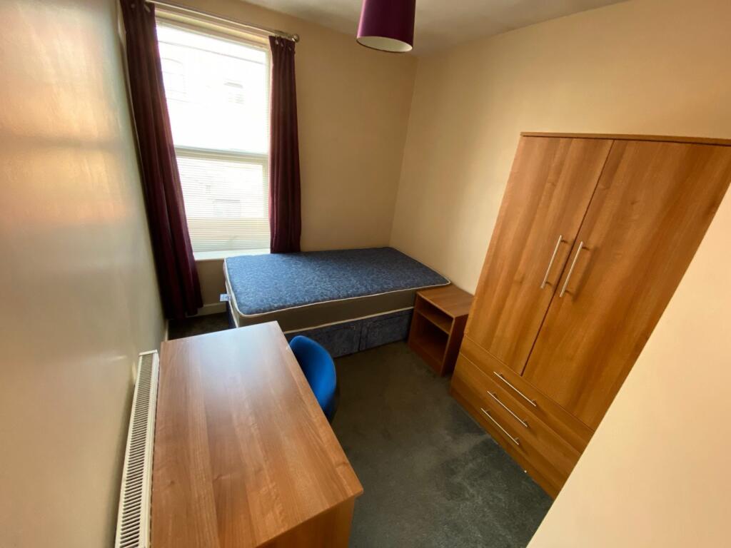 A bright and tidy double bedroom featuring mode...